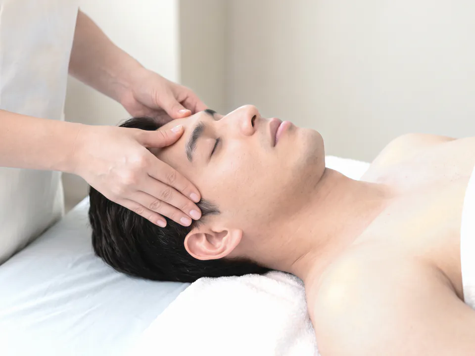 Professional therapist giving a head massage